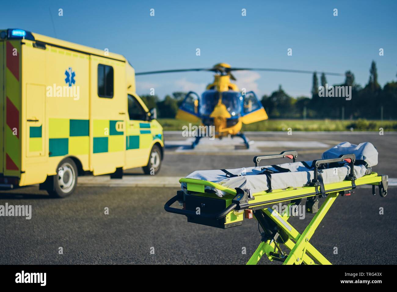 Barella contro ambulanza e elicottero del servizio di emergenza medica. Temi di salvataggio, aiuto e speranza. Foto Stock