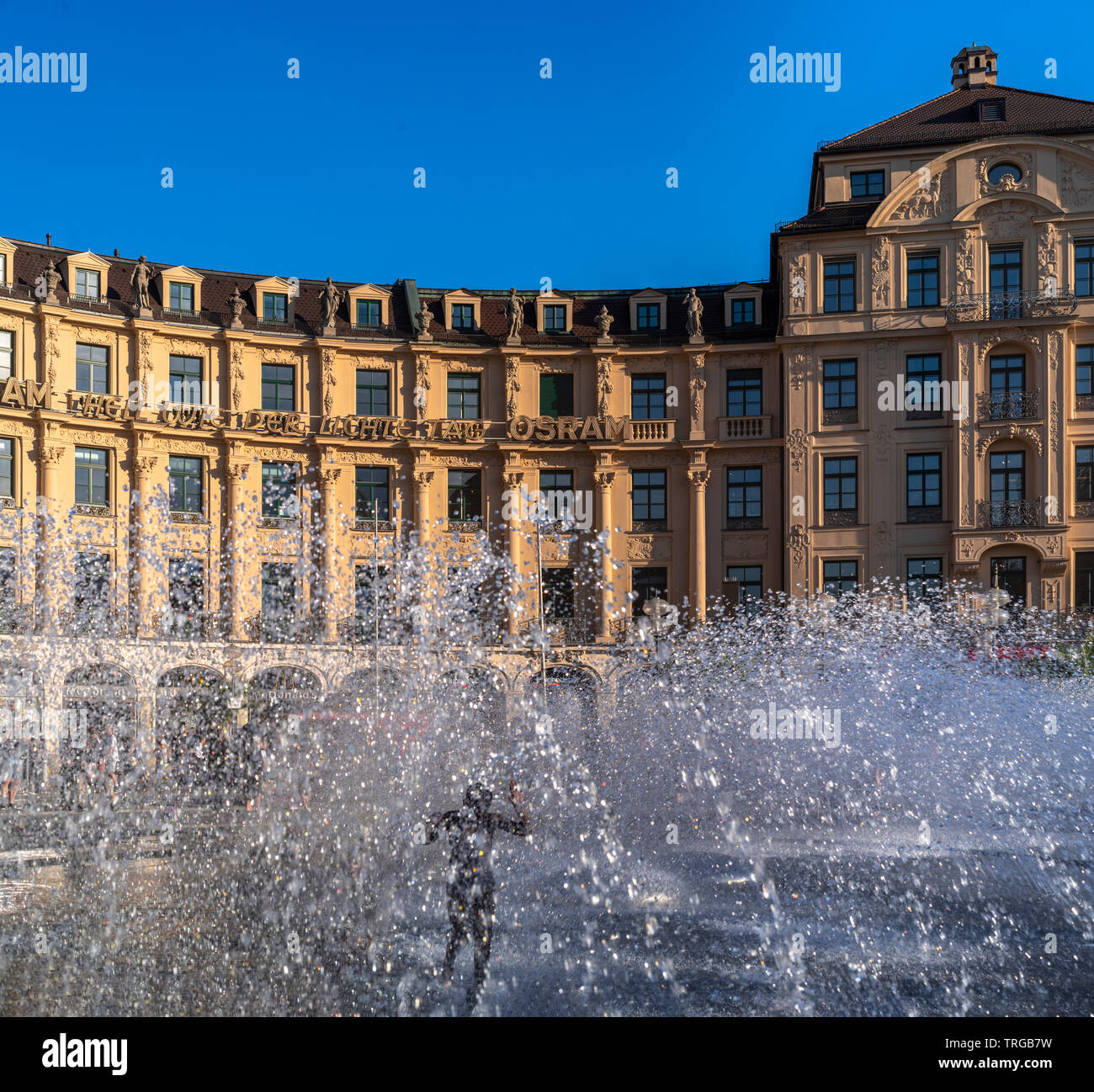 Kind im Springbrunnen, München an einem heißen Frühsommertag im Juni Foto Stock