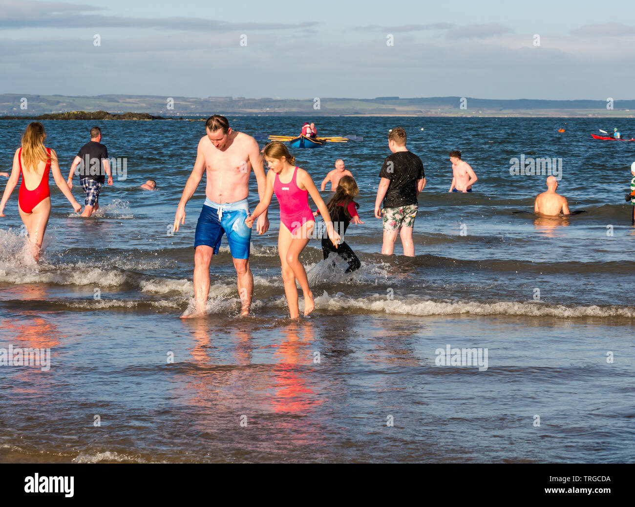 Loony Dook, primo giorno del nuovo anno: persone brave acqua fredda, West Bay, Firth of Forth, North Berwick, East Lothian, Scozia, Regno Unito. Le persone escono dal mare Foto Stock