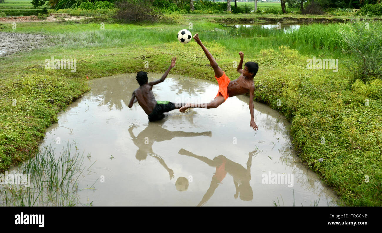 Due bambini godendo il loro gioco di calcio al remoto villaggio dell India Foto Stock