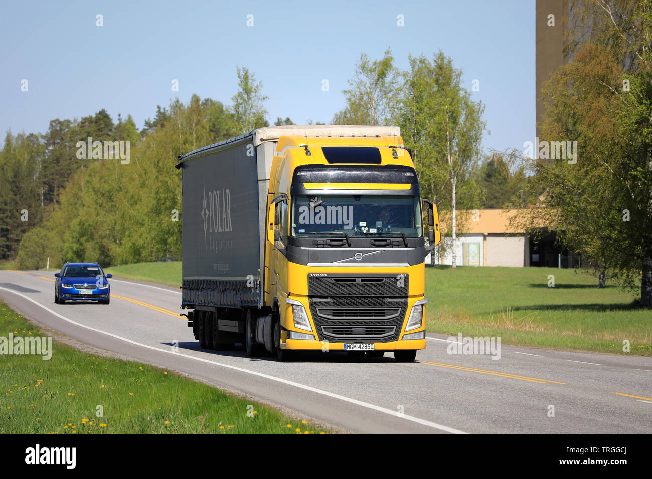 Salo, Finlandia - 17 Maggio 2019: Giallo Volvo FH semi rimorchio trasporto su strada in una giornata di sole di primavera nel sud della Finlandia. Foto Stock