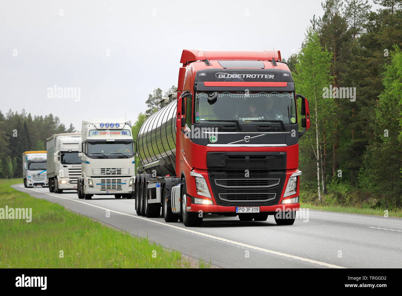 Raasepori, Finlandia. Il 24 maggio 2019. Flotta di quattro autocarri pesanti guidati da un rosso Volvo FH 500 semi tanker sull autostrada in un nuvoloso giorno di estate in Finlandia. Foto Stock