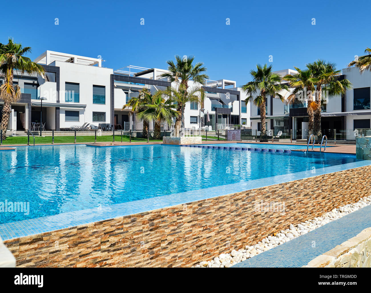 Torrevieja, Spagna - 1 Maggio 2019: Vista di nuova costruzione moderna cittadina case chiuse urbanizzazione con piscina palme, lussuoso edificio residenziale Foto Stock