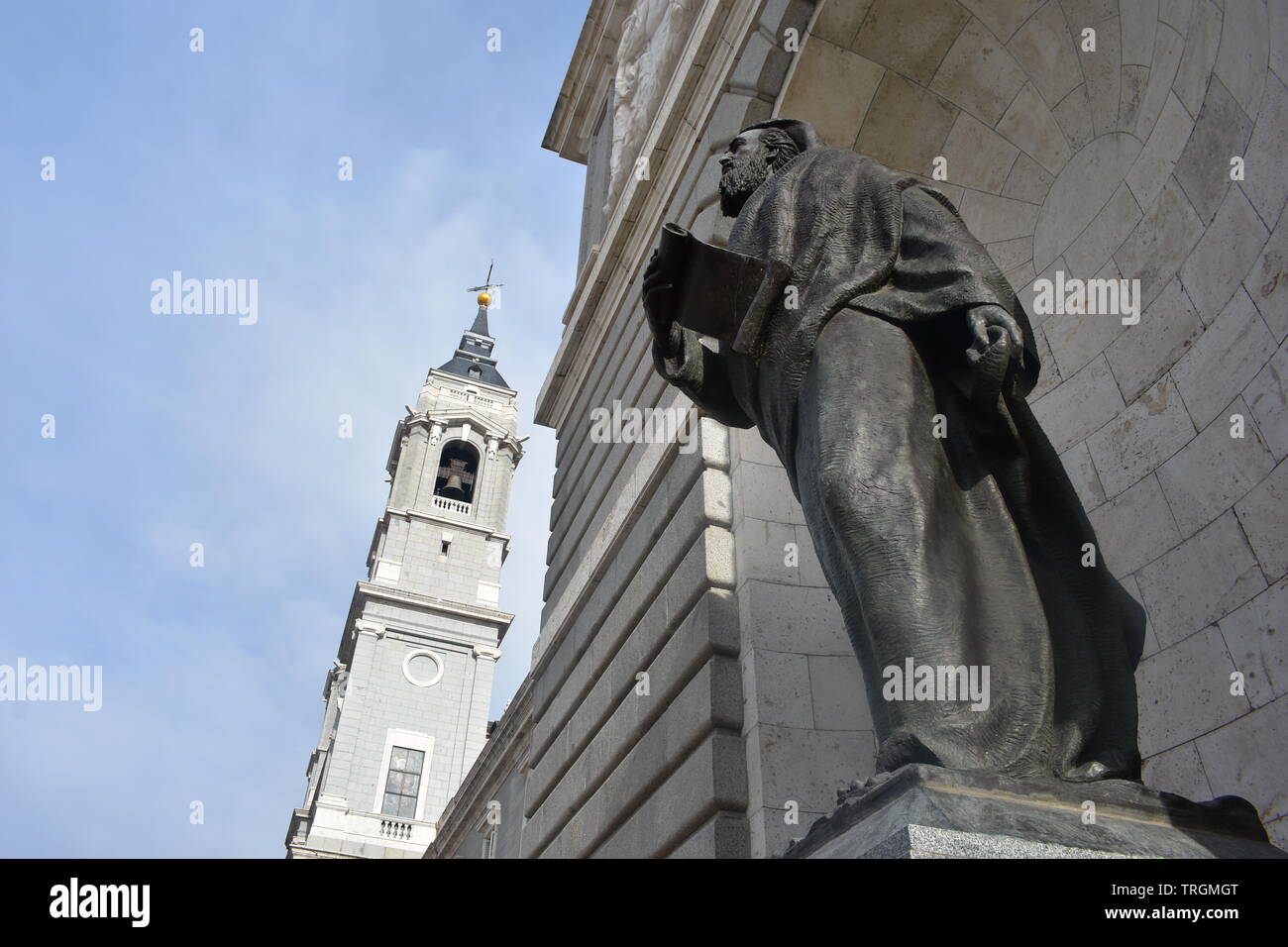 Fotografia in prospettiva della Cattedrale di Almudena concentrandosi strettamente sulla destra la statua della facciata di ingresso Foto Stock