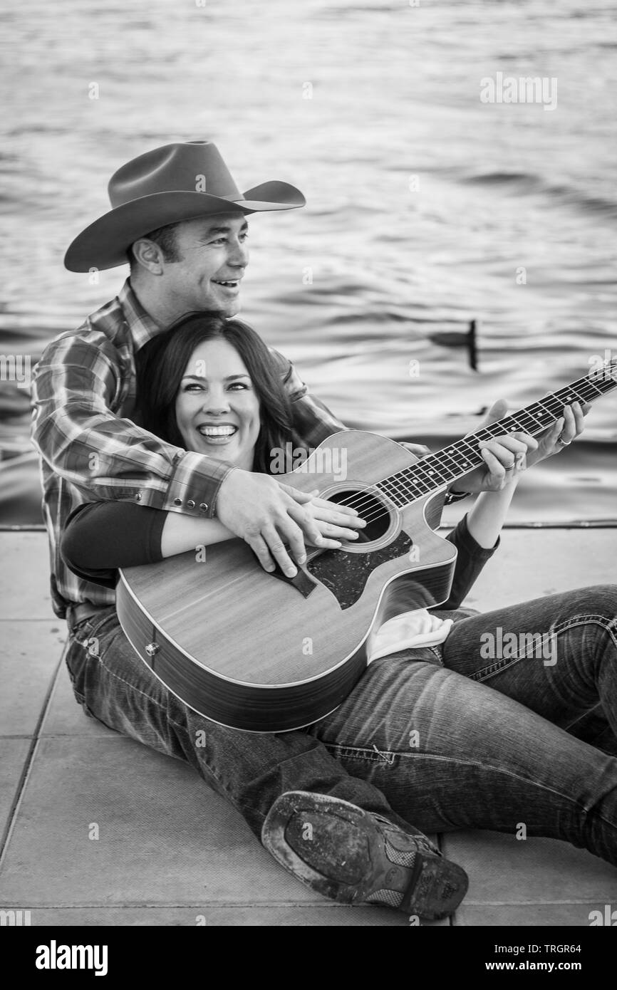 Coppia di campagna su un Dock Romantico, riproduzione di musica Foto Stock