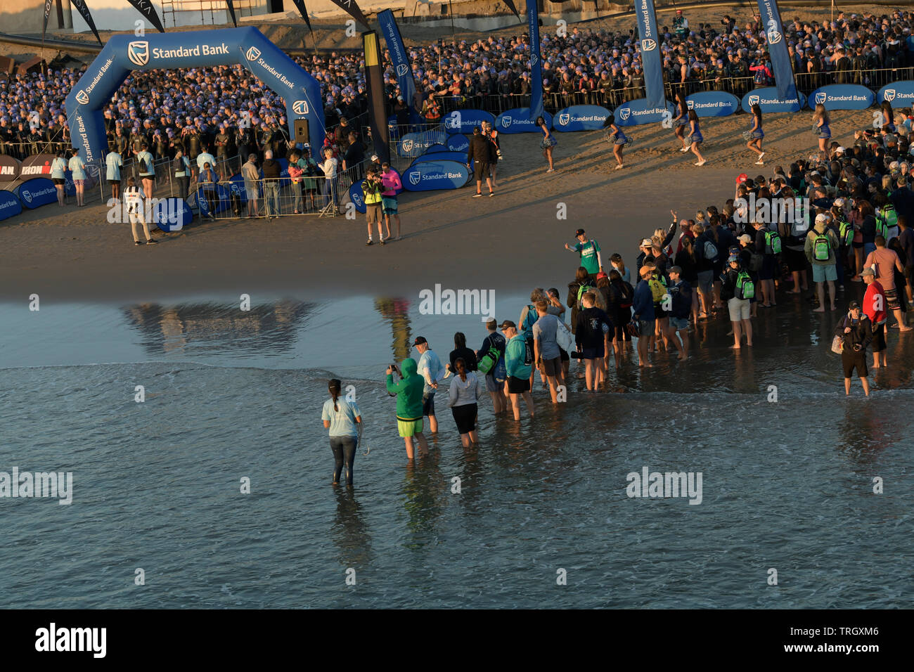 Triatleti, funzionari, la folla in attesa sulla spiaggia per iniziare, nuoto gamba di triathlon, 2019, Ironman 70,3, Durban, KwaZulu-Natal, Sud Africa, sport Foto Stock