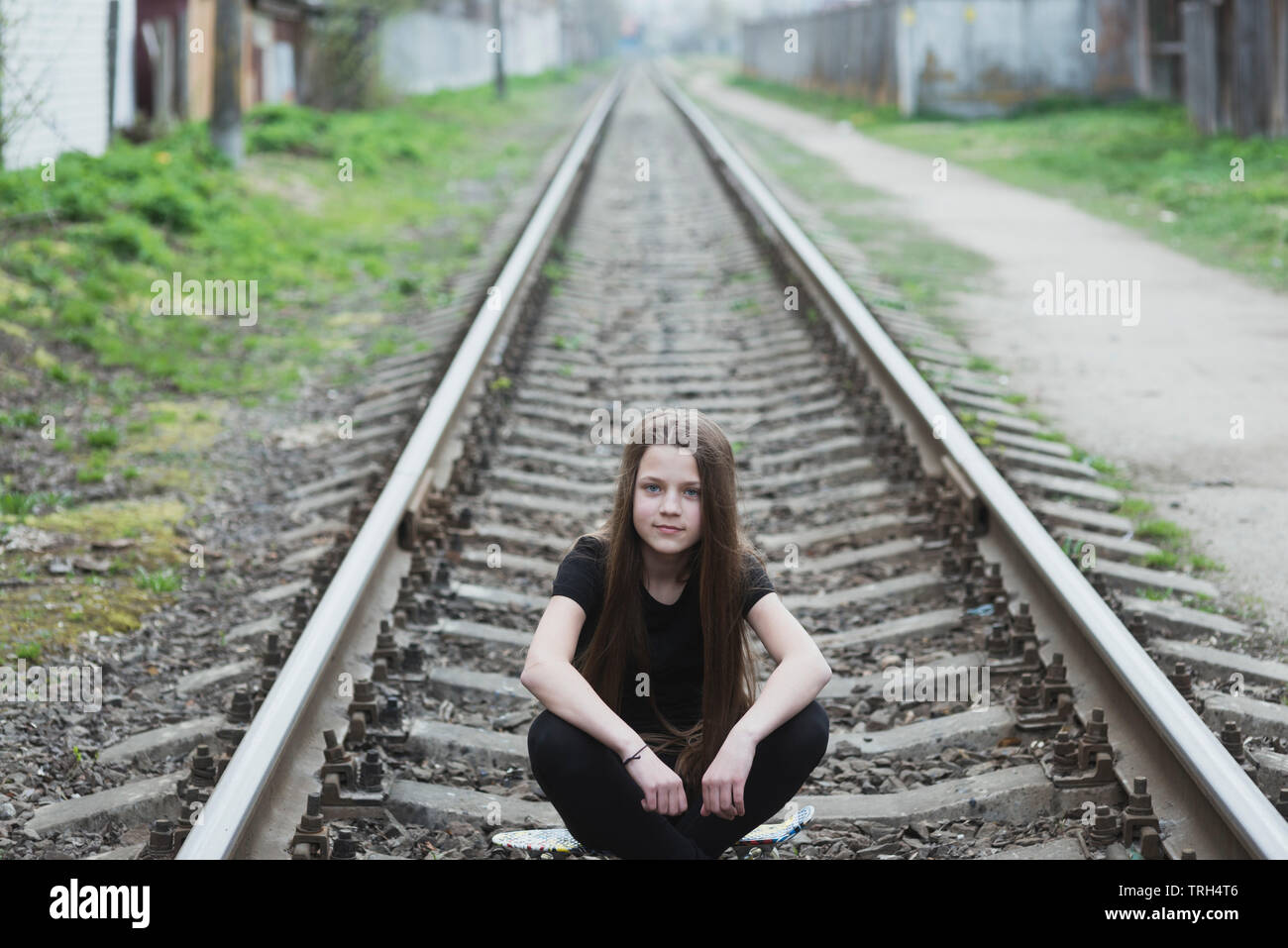 Bambino ragazza seduta su binari ferroviari Foto Stock