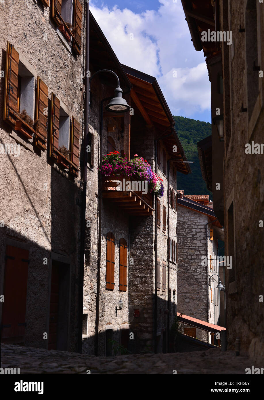 Tipica strada stretta con balcone e fiori in italiano città di montagna. Erto e Casso. Italia Foto Stock