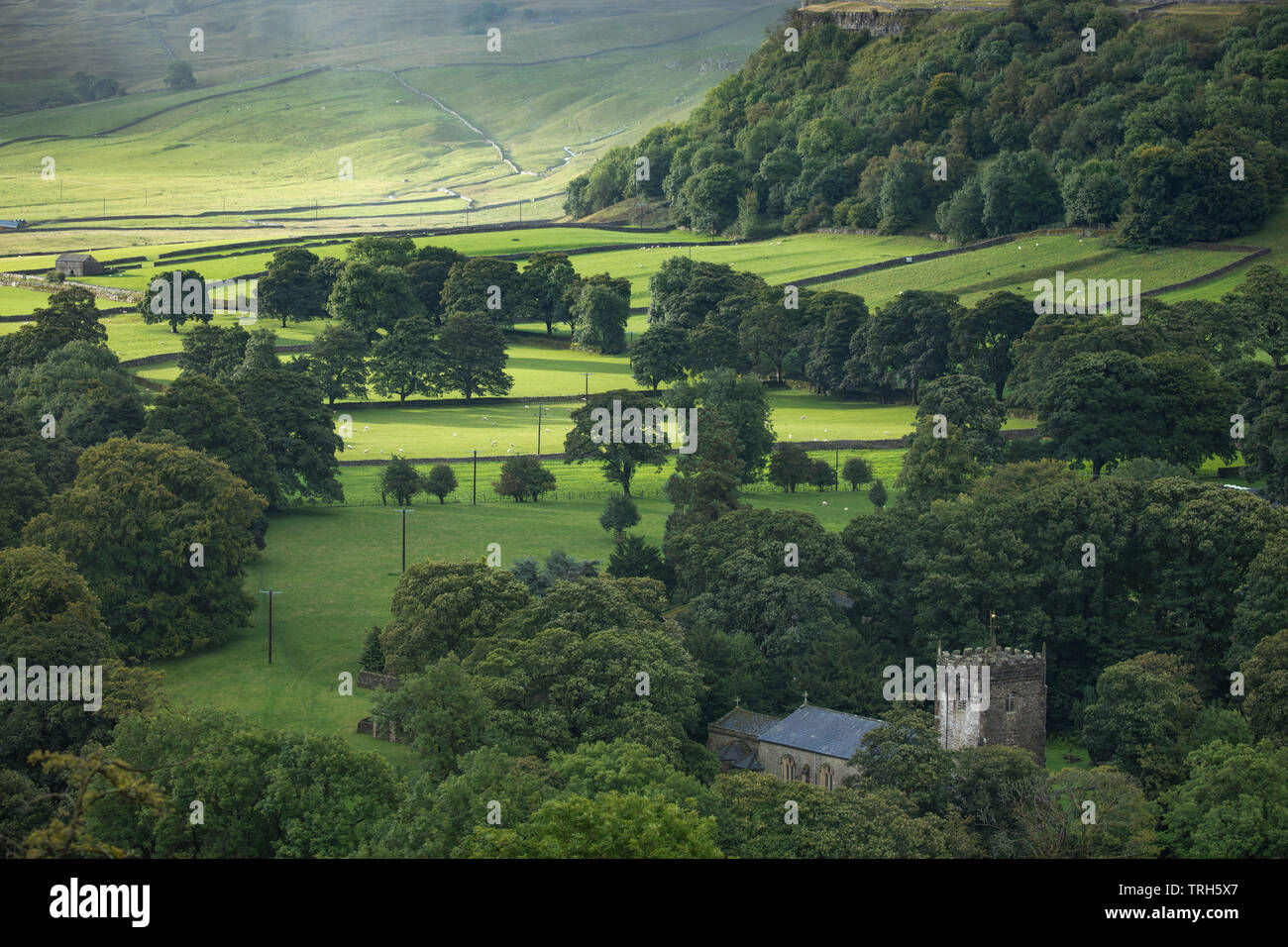 Un fugace patch di luce sulla Chiesa Arncliffe & Littondale sotto la pioggia, Yorkshire Dales National Park, England, Regno Unito Foto Stock