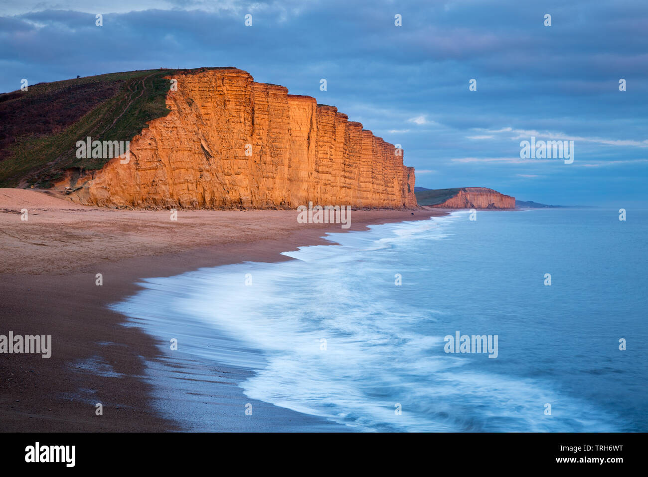 Onde che si infrangono sulla spiaggia al di sotto dell Oriente scogliere, West Bay, Jurassic Coast, Dorset, England, Regno Unito Foto Stock