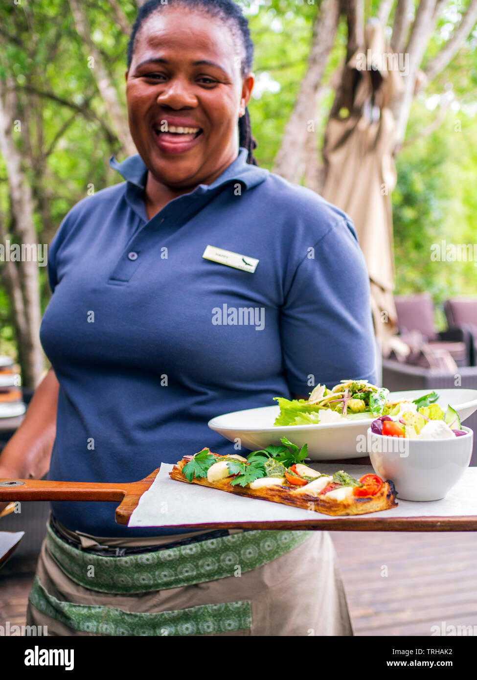 Un membro del personale serve il pranzo presso il Phinda Forest Lodge, uno dei numerosi alberghi di lusso all'interno del Phinda Private Game Reserve,Sud Africa. Foto Stock