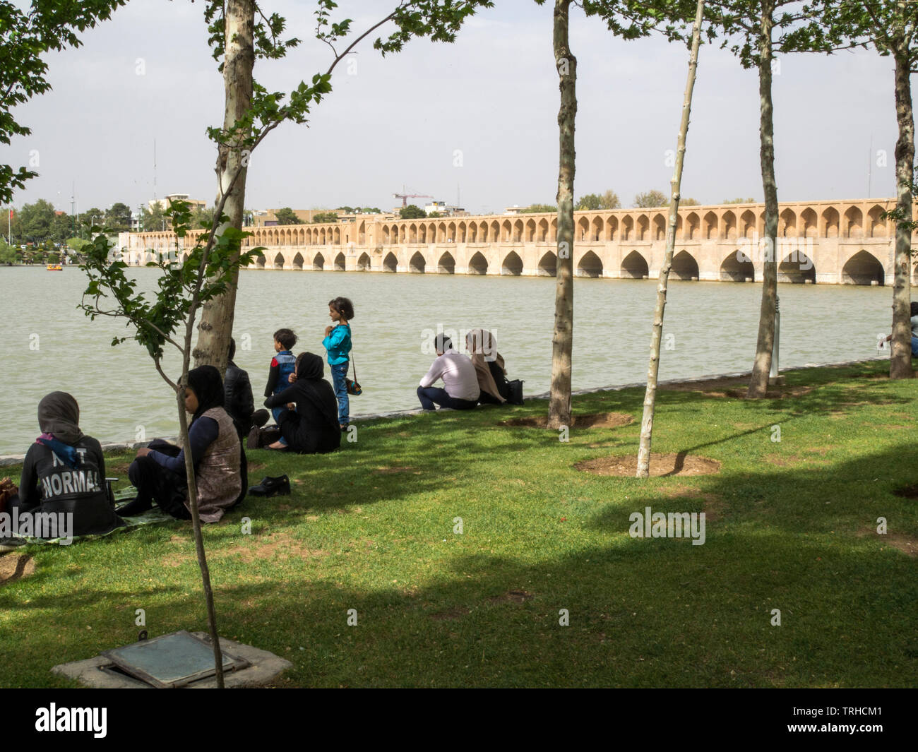 Persone che si rilassano e socializzano presso il Ponte di Siosepol, costruito nel 1599, il ponte più lungo sul fiume Zayanderud dell'Iran. Foto Stock