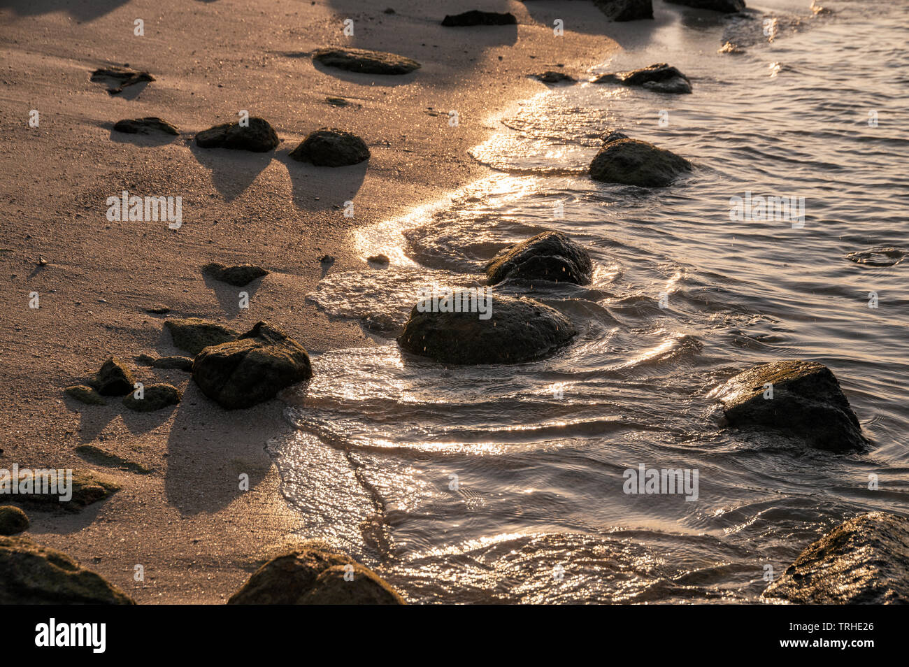Rocce sulla costa nel mare tropicale al tramonto Foto Stock