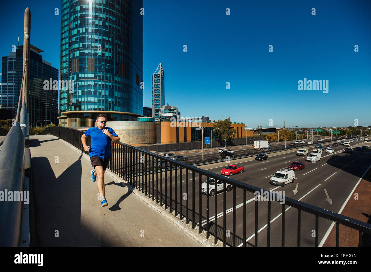 Una vista anteriore colpo di un caucasian metà uomo adulto jogging in città in una calda giornata estiva a Perth in Australia. Foto Stock