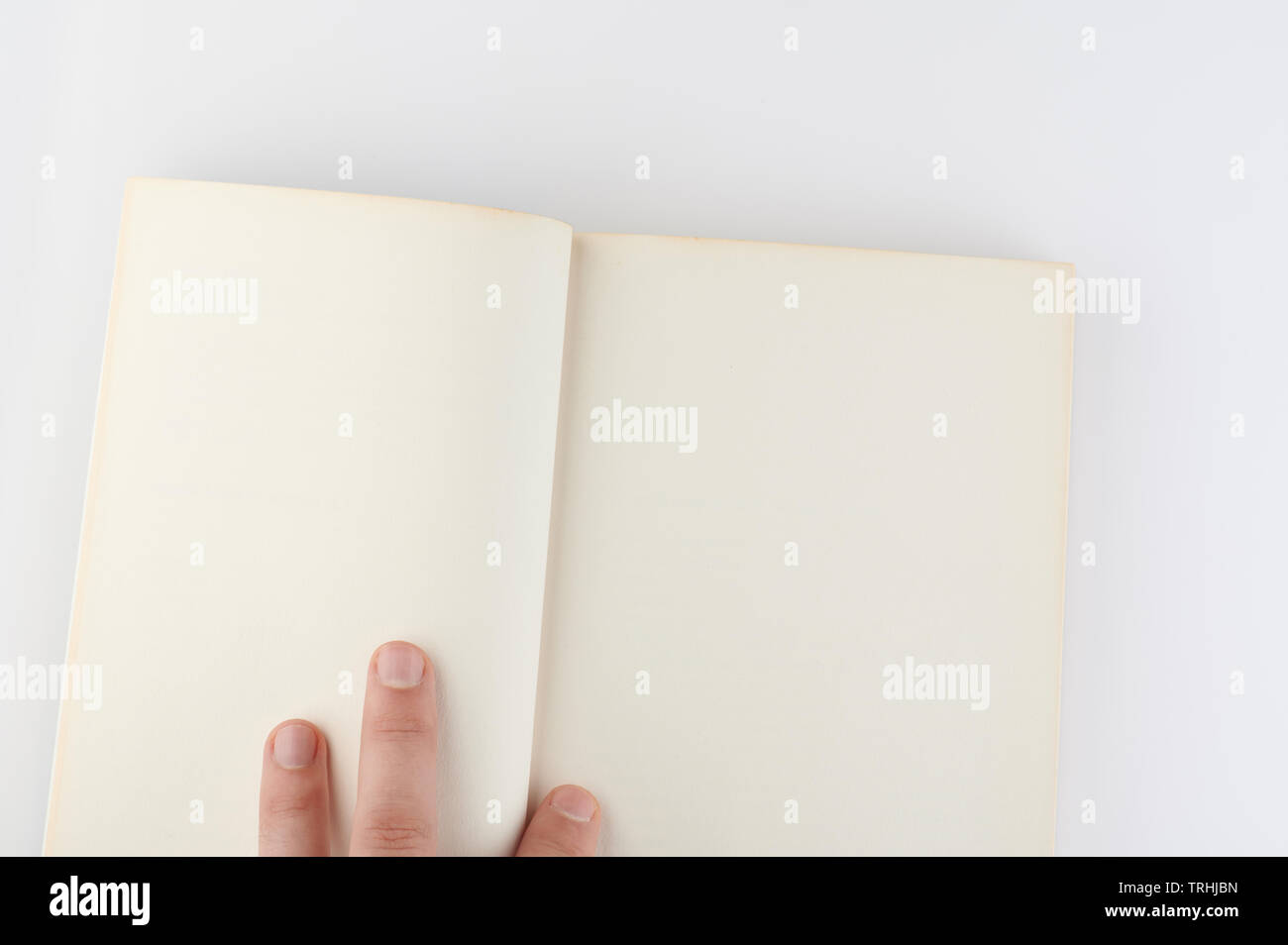 Hand Lay su vuoto libro aperto isolata su sfondo bianco Foto Stock