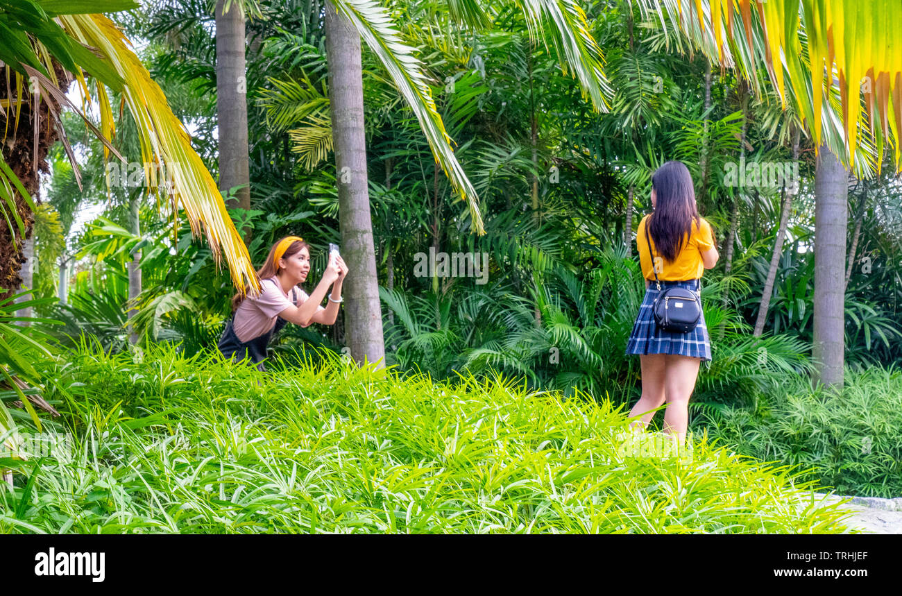 Due Asian Instagrammers femmina in posa e tenendo ancora a giardini dalla Baia di Singapore. Foto Stock