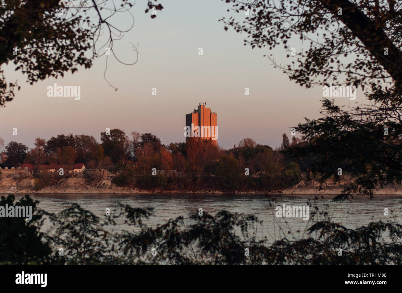 Lone edificio circondato dal verde sul lato opposto del fiume Danubio Foto Stock