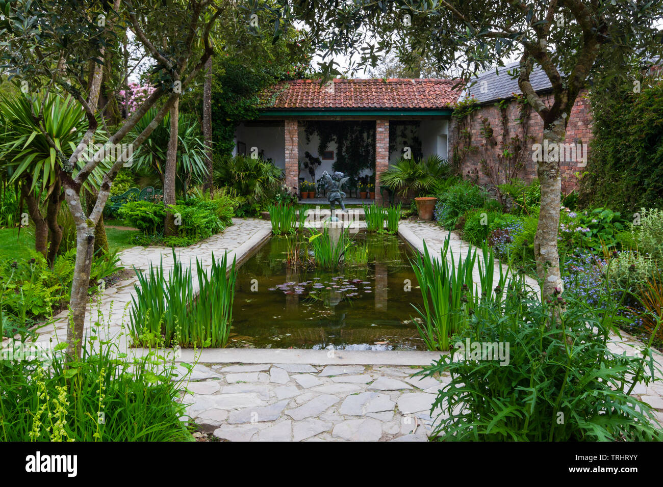 Formale di lily pond con surround lastricate e le piantine in teh giardino italiano presso il Lost Gardens of Heligan, Cornwall, Regno Unito Foto Stock