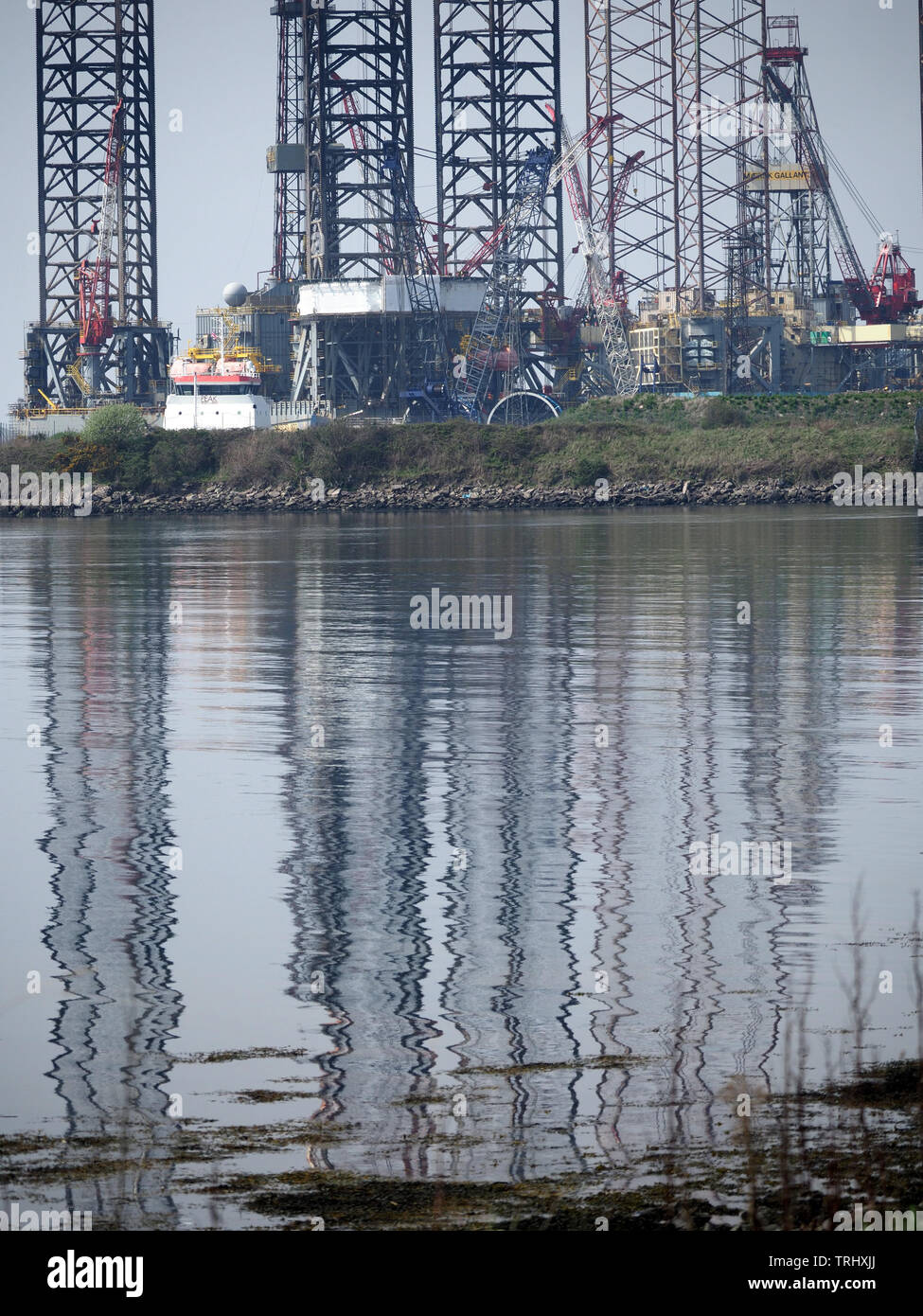 La riflessione di olio-rig portali nei paesi industrializzati area portuale di Dundee, sul Firth of Tay in Scozia, Regno Unito Foto Stock