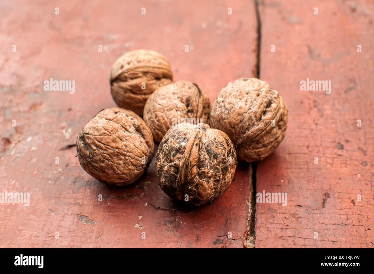 Tutta i gusci di noce closeup su vecchie tavole di legno come superficie di sfondo Foto Stock