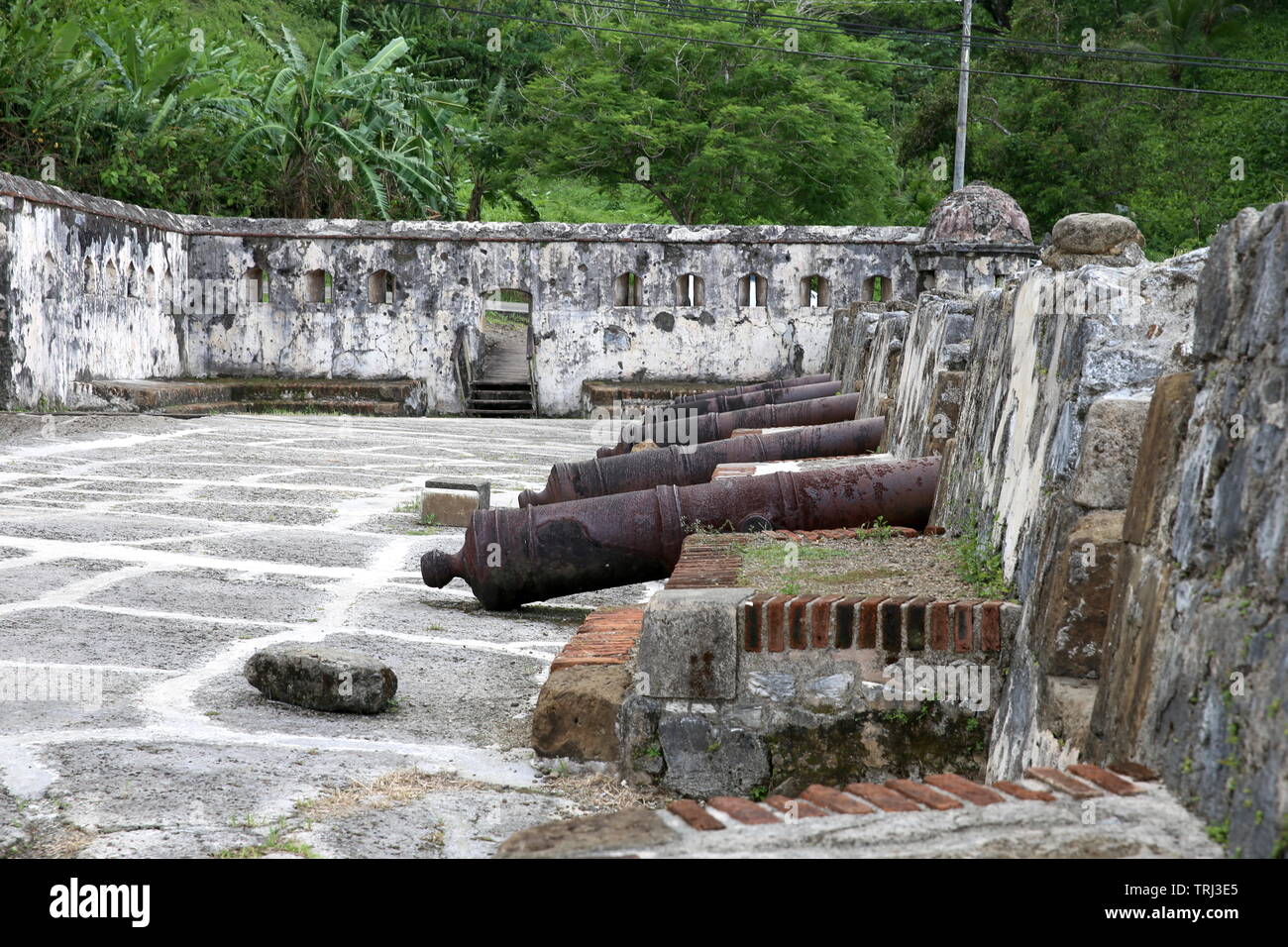 Vecchi cannoni si allineano nelle mura storiche di Portobelo, Panama Foto Stock