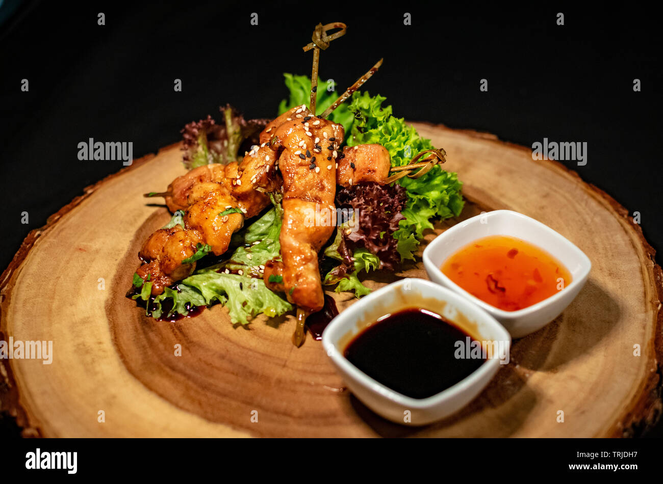 Un incredibile look fresco per un pollo teriyaki spillone starter pietanza accompagnata da una selezione di salse Foto Stock