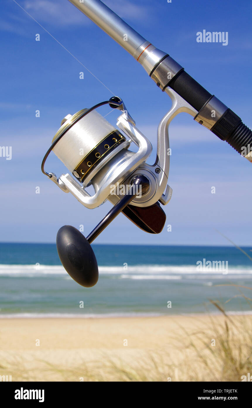 Close-up sul mulinello da pesca con l'oceano sullo sfondo Foto Stock