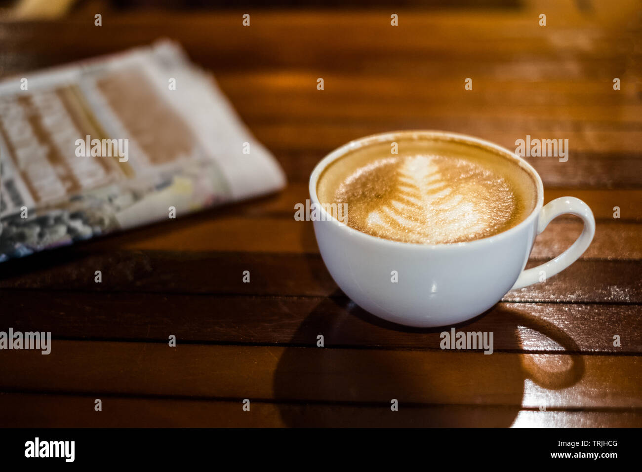 Latte caldo tazza da caffè con il giornale sul tavolo di legno Foto Stock
