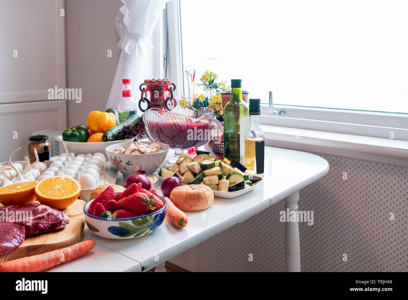 Ingrediente con molti alimenti, ortaggi e frutta per preparare la cena sul tavolo da pranzo Foto Stock