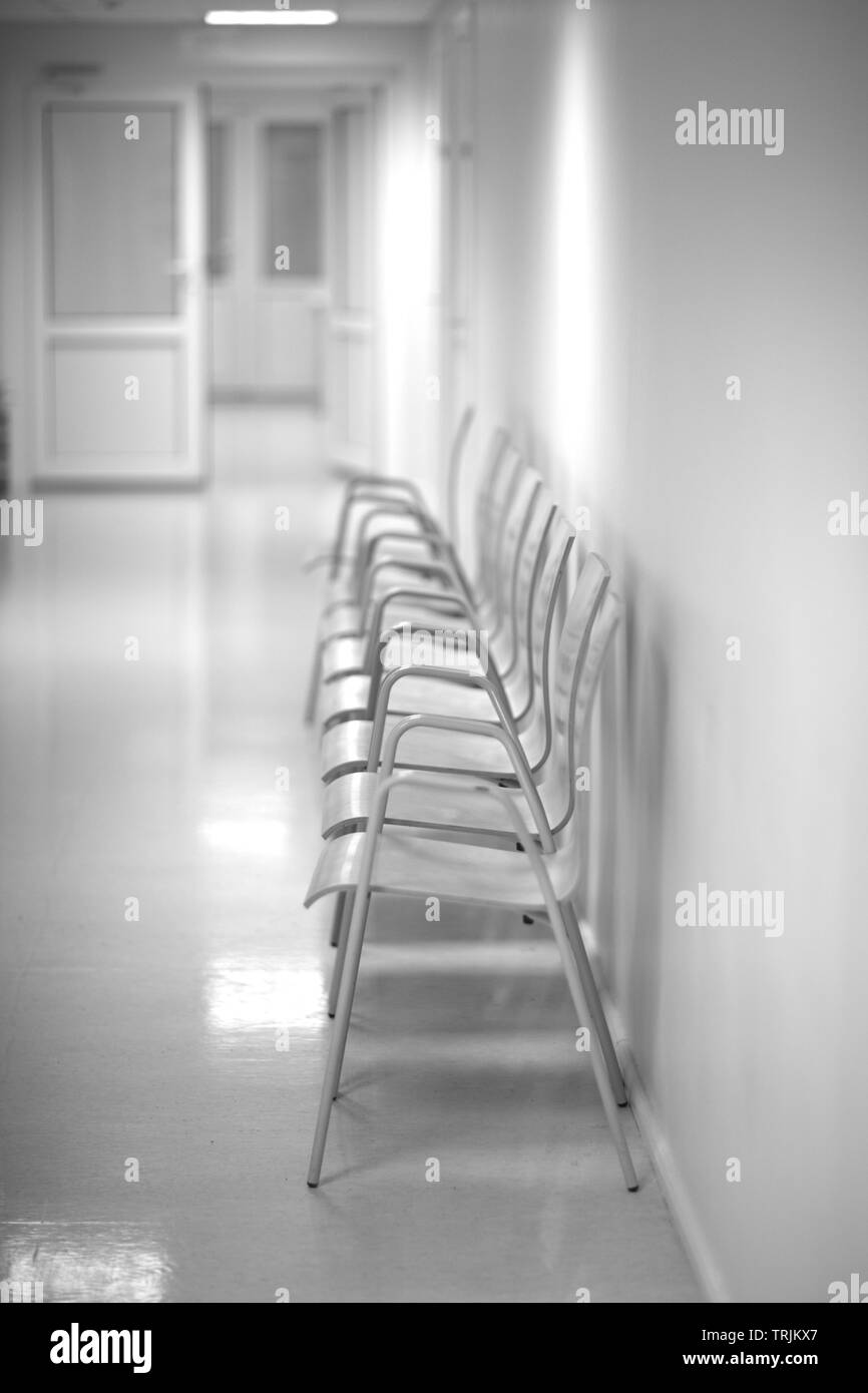 Sedie per i pazienti in attesa di un medico in ospedale reception corridoio Foto Stock