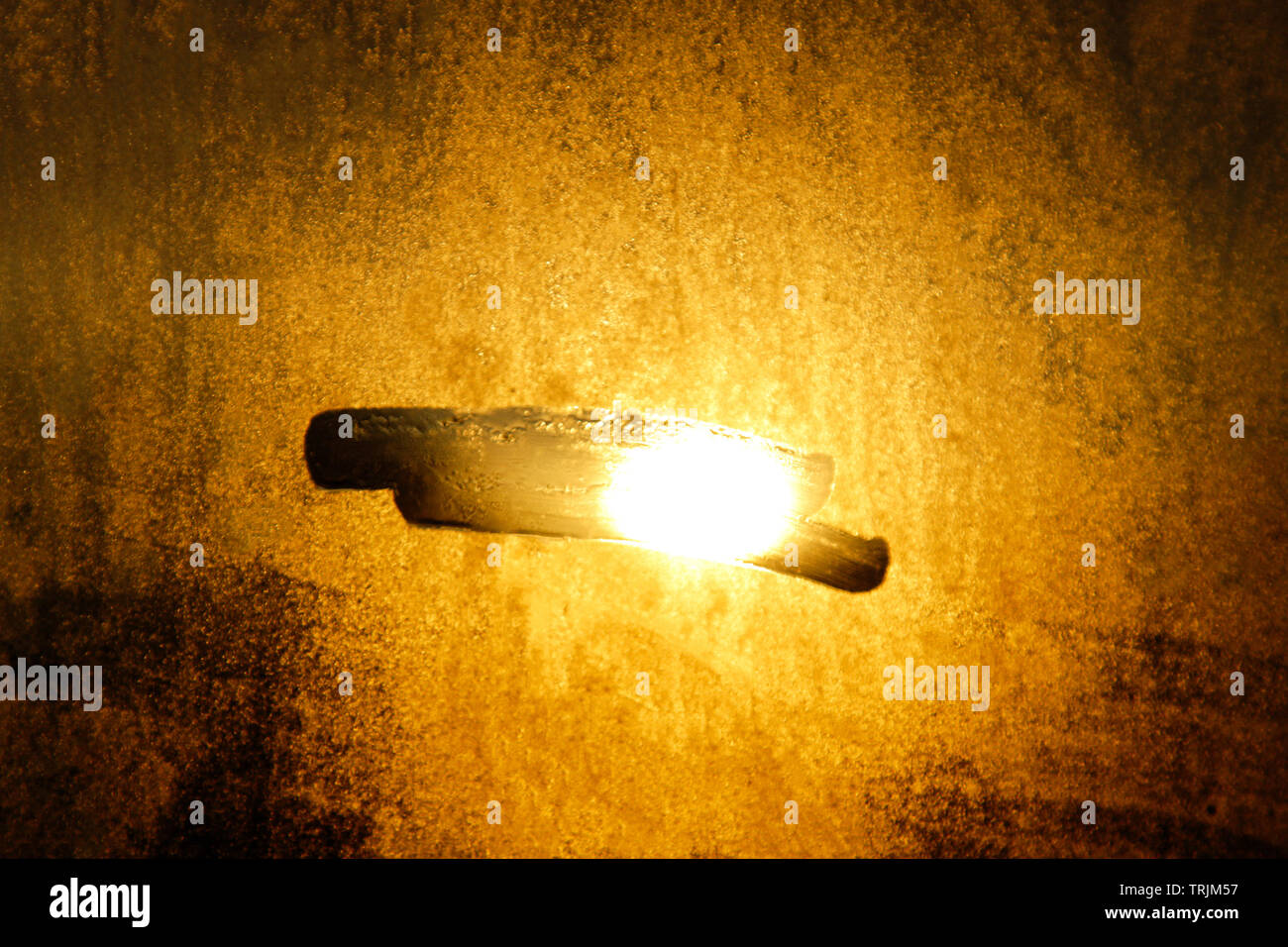 Un raggio di sole proveniente attraverso le persiane di legno, illumina la polvere all'interno di una camera oscura. Close up, il fuoco selettivo. Sfondo vintage. Foto Stock