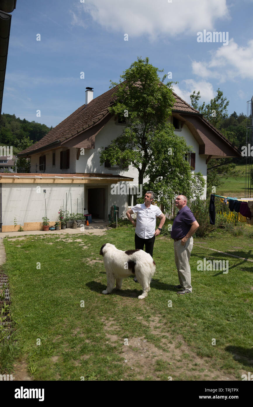 Conversazione tra due uomini dietro un antico del XIX secolo agriturismo svizzero in Argovia, Svizzera. Foto Stock