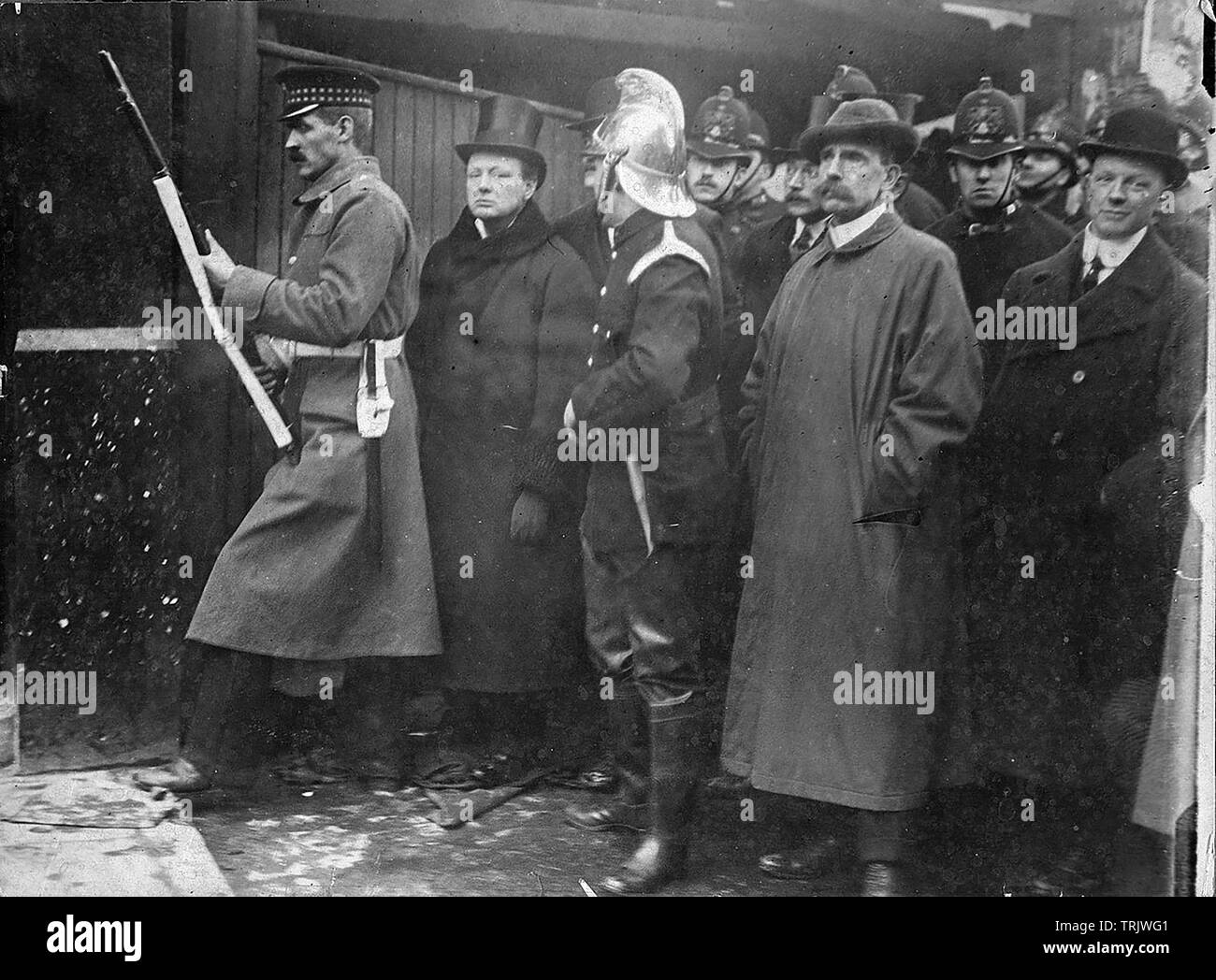 Assedio di Sidney Street, Londra, Gennaio 1911 con Home Secretary Winston Churchill secondo da sinistra affiancato da un Guardsman irlandese e un vigile del fuoco Foto Stock