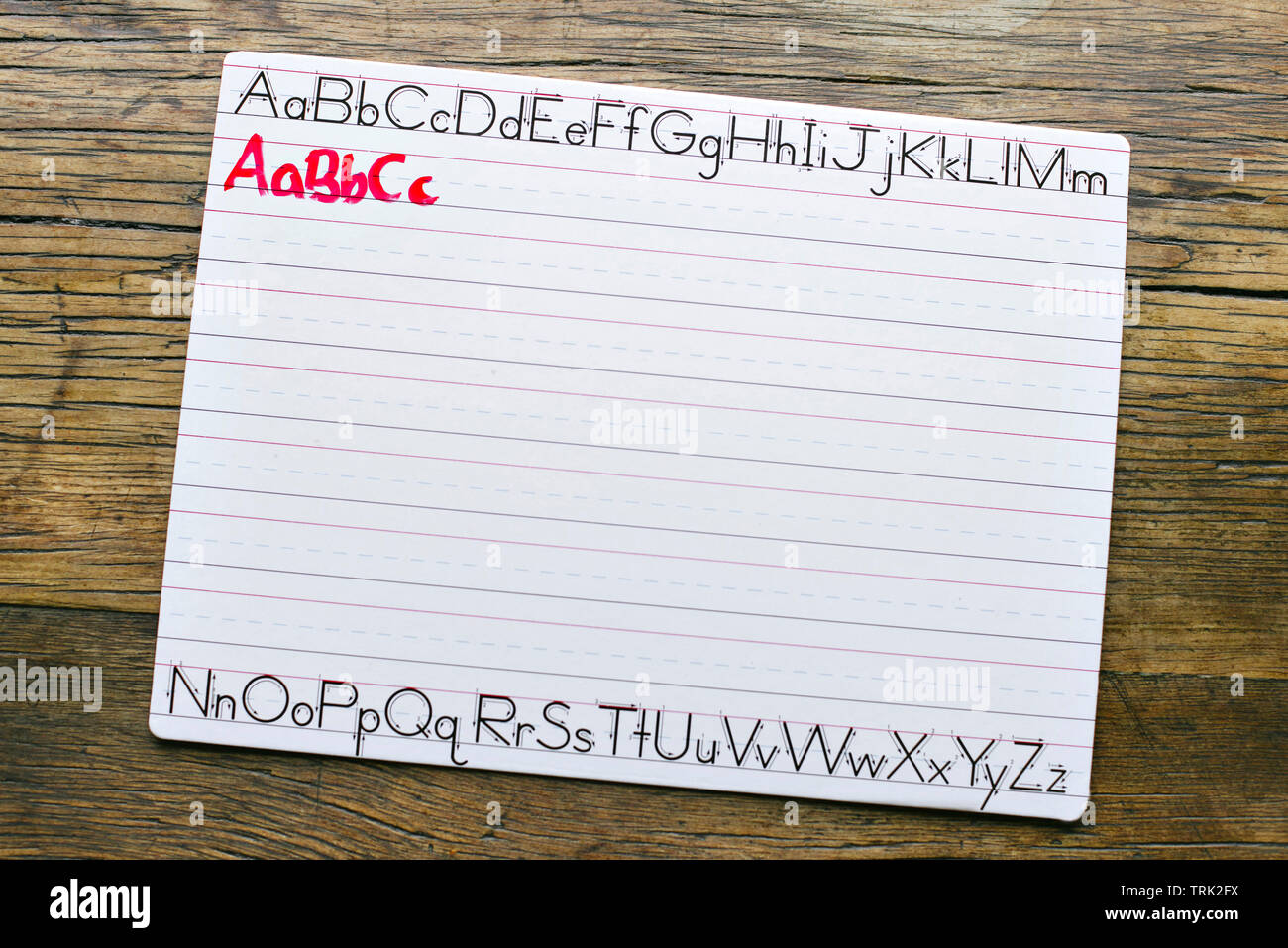 Vista dall'alto di una calligrafia bianco bordo con le lettere ABC scritto in rosso marcatore da un bambino Foto Stock