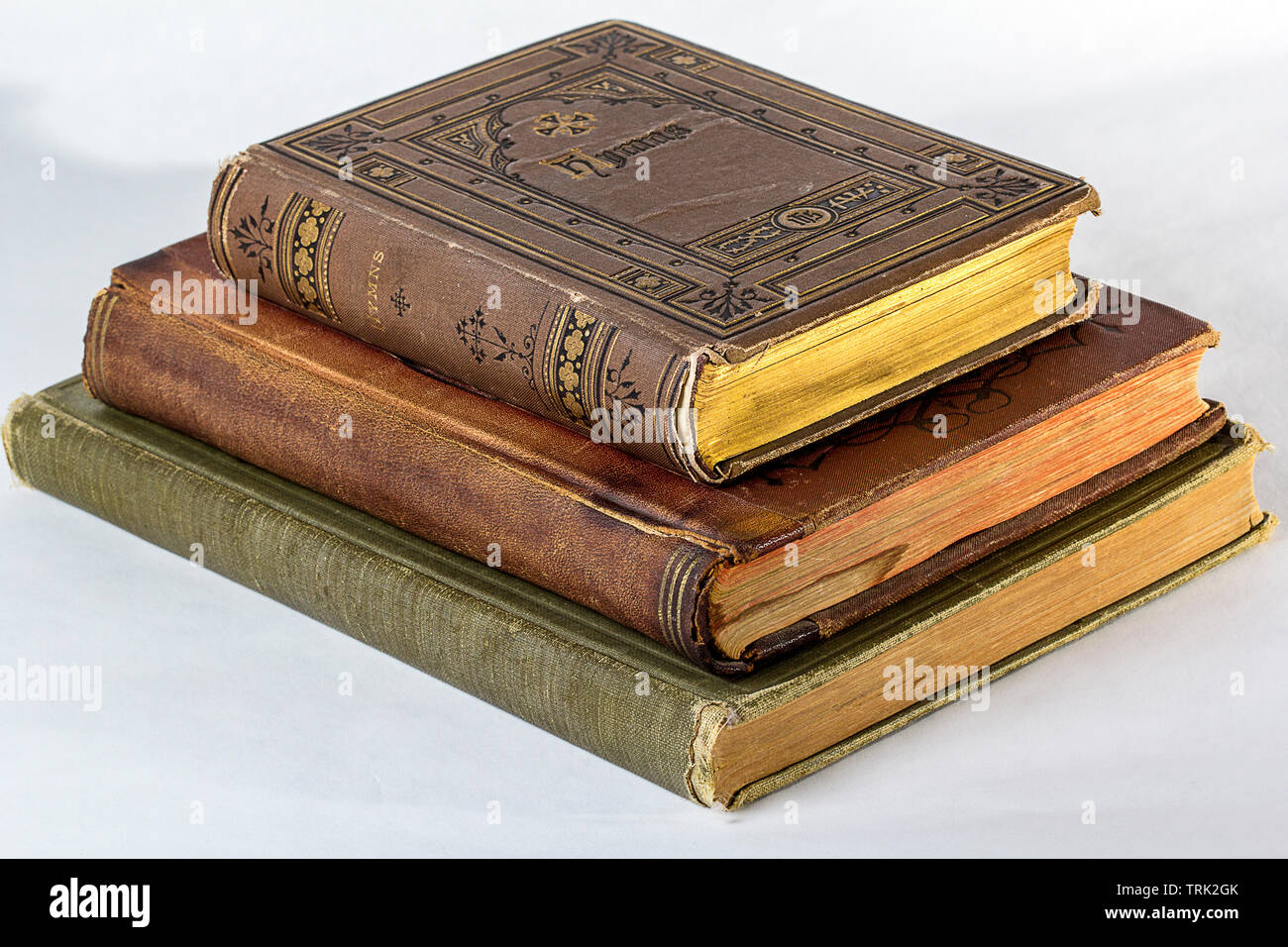 Pila di tre libri antichi su uno sfondo bianco. Foto Stock