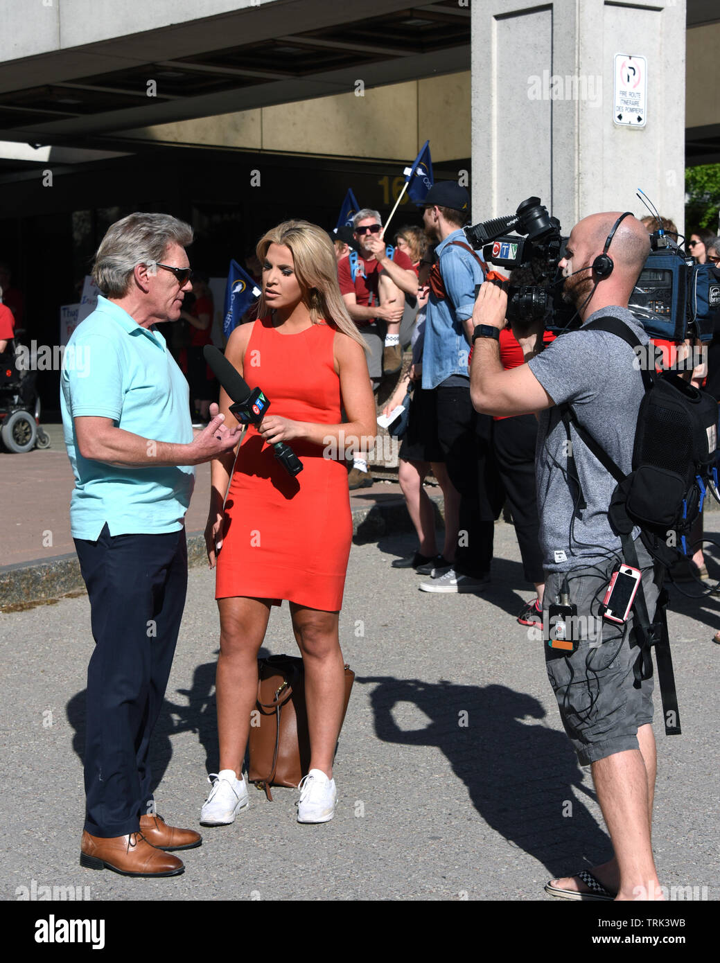 Ottawa, Canada - 7 Giugno 2019: CTV reporter Christina Succi interviste Sean McKenney, presidente di Ottawa e distretto al consiglio di lavoro, alla protesta per l'Ontario Premier Doug Ford un anno dopo fu eletto. Foto Stock