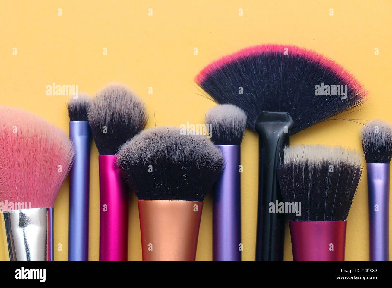 Colorata viso e occhi make up pennelli in una riga Foto Stock