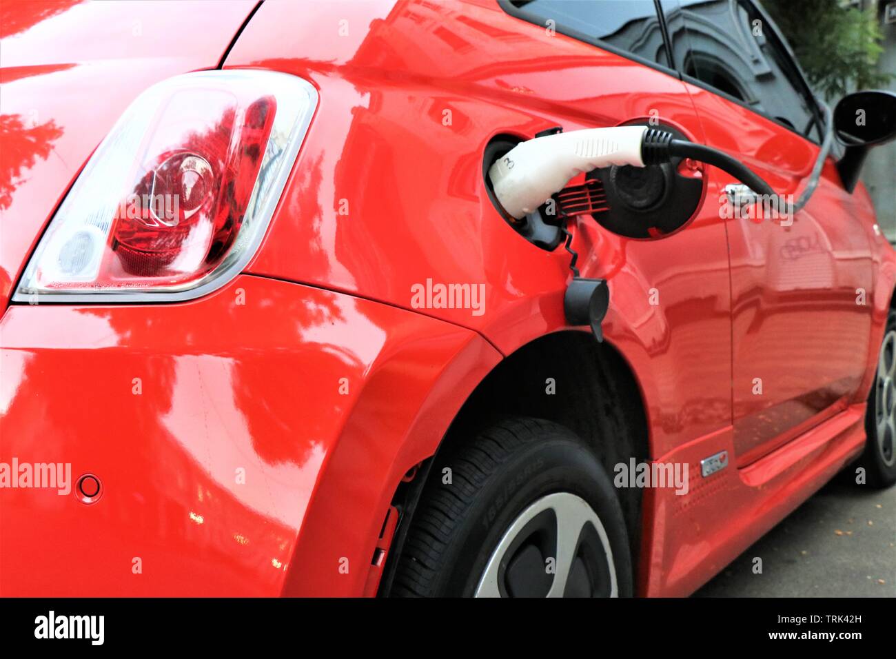 Punto di caricabatterie per auto elettriche. Il futuro contro l'inquinamento. Auto collegato alla corrente elettrica. Foto Stock
