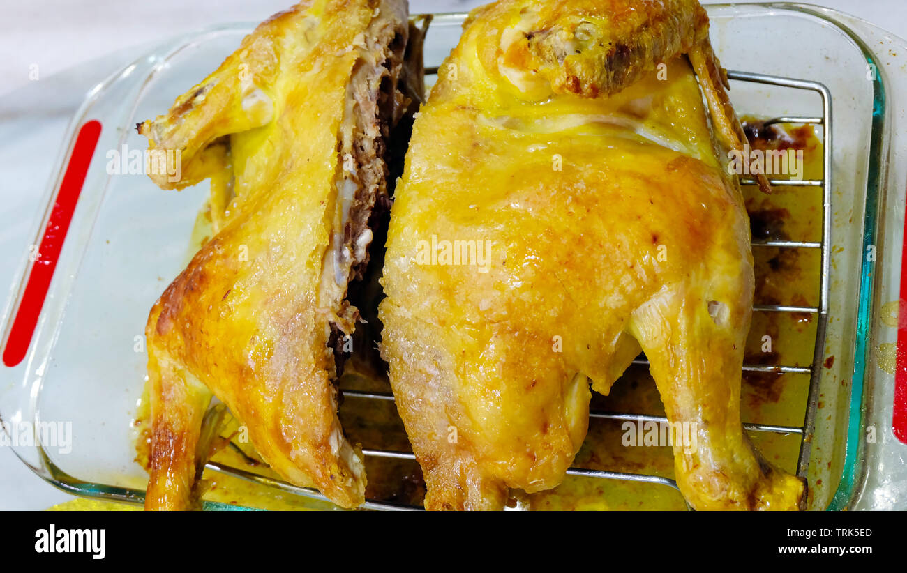 Il pollo al forno in un piatto di vetro con dorate e croccanti della pelle. Foto Stock