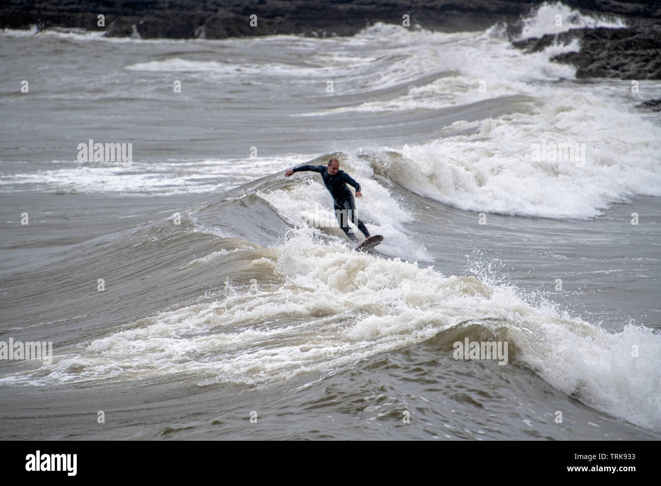 Un uomo di mezza età in muta umida che mostra la sua abilità. Resto Bay, Porthcawl, Regno Unito Foto Stock