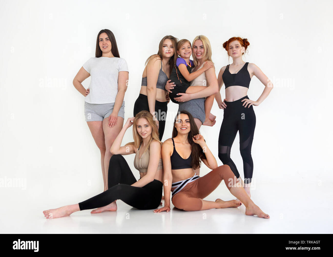 Felice gara diverse donne che indossano sport top e leggings sembra perfetto e si sono riuniti presso studio fitness per la formazione insieme. Multirazziale sporty fema Foto Stock