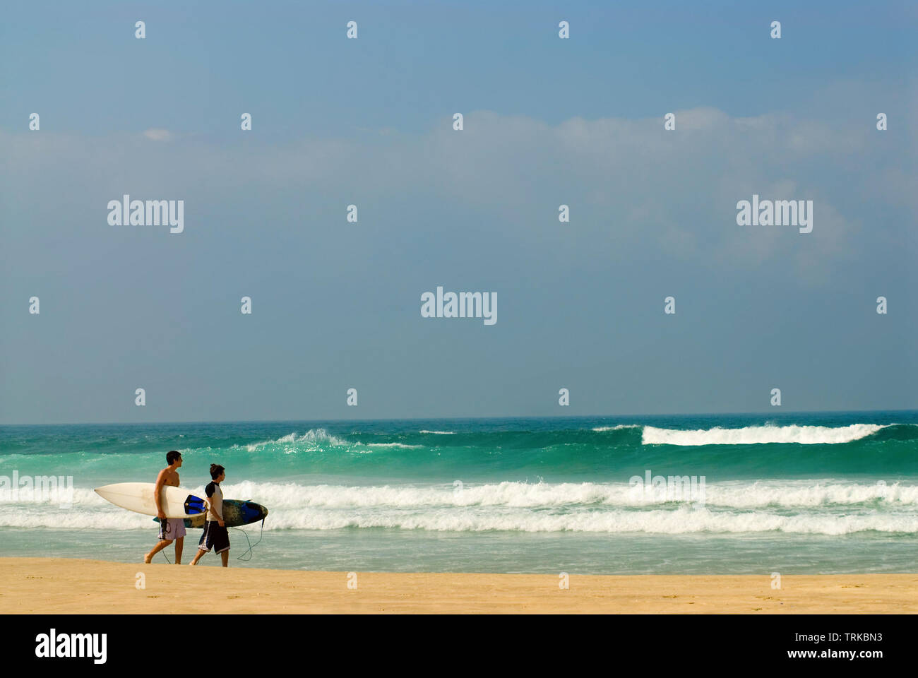 Due persone di sesso maschile con la tavola da surf a piedi lungo il mare Foto Stock