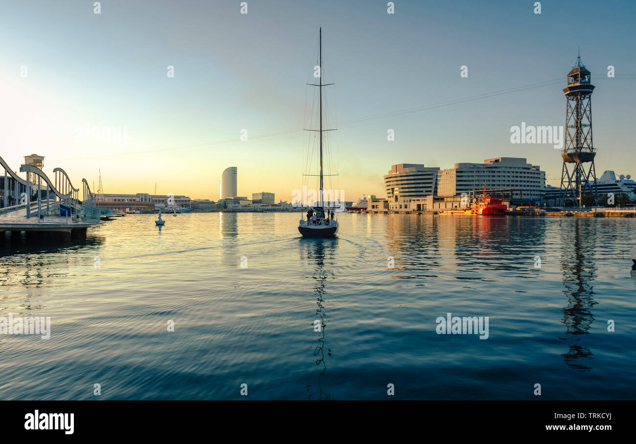 Barca a vela di lasciare il porto, all'alba con il mare calmo, sensazione di tranquillità, il relax e la pace Foto Stock Barca a vela di lasciare il porto, all'alba con il mare calmo, sensazione di tranquillità, il relax e la pace Foto Stock
