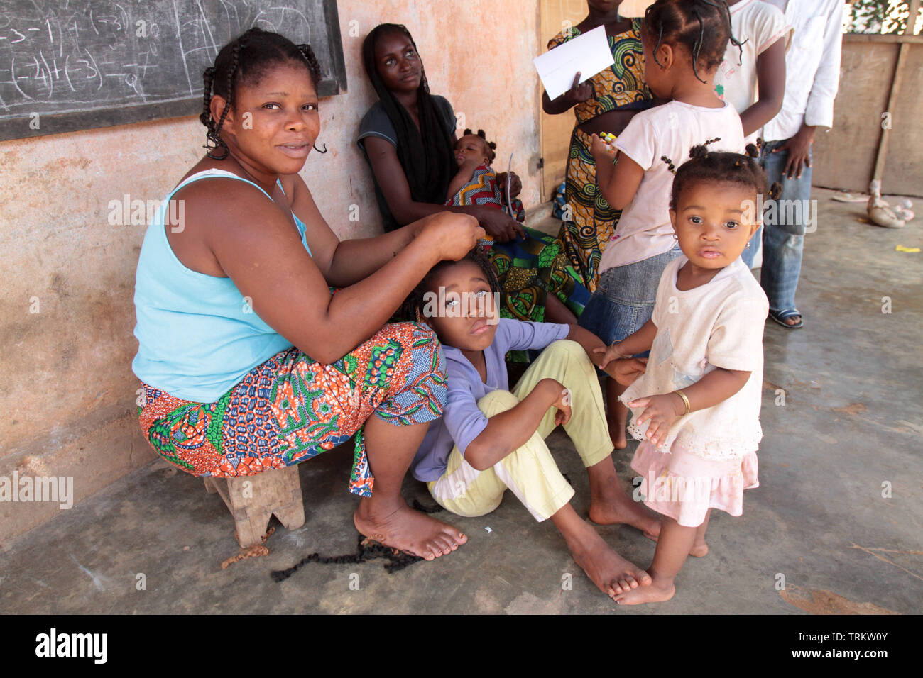 Maman togolaise posant des extensions sur les cheveux de sa fille. La convenzione di Lomé. Il Togo. Afrique de l'Ouest. Foto Stock