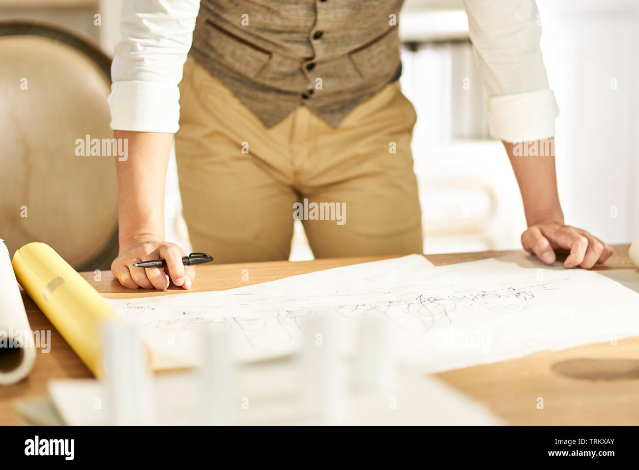 Giovani asiatici architetto designer in piedi fromt del banco di lavoro a casa Foto Stock