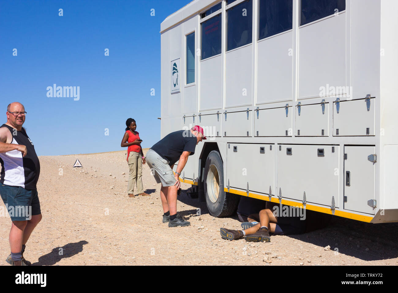 African overland tour carrello o veicolo rotto verso il basso e bloccata in posizione sul lato di un deserto deserta strada sterrata in Namibia, in Africa con la gente e i turisti Foto Stock