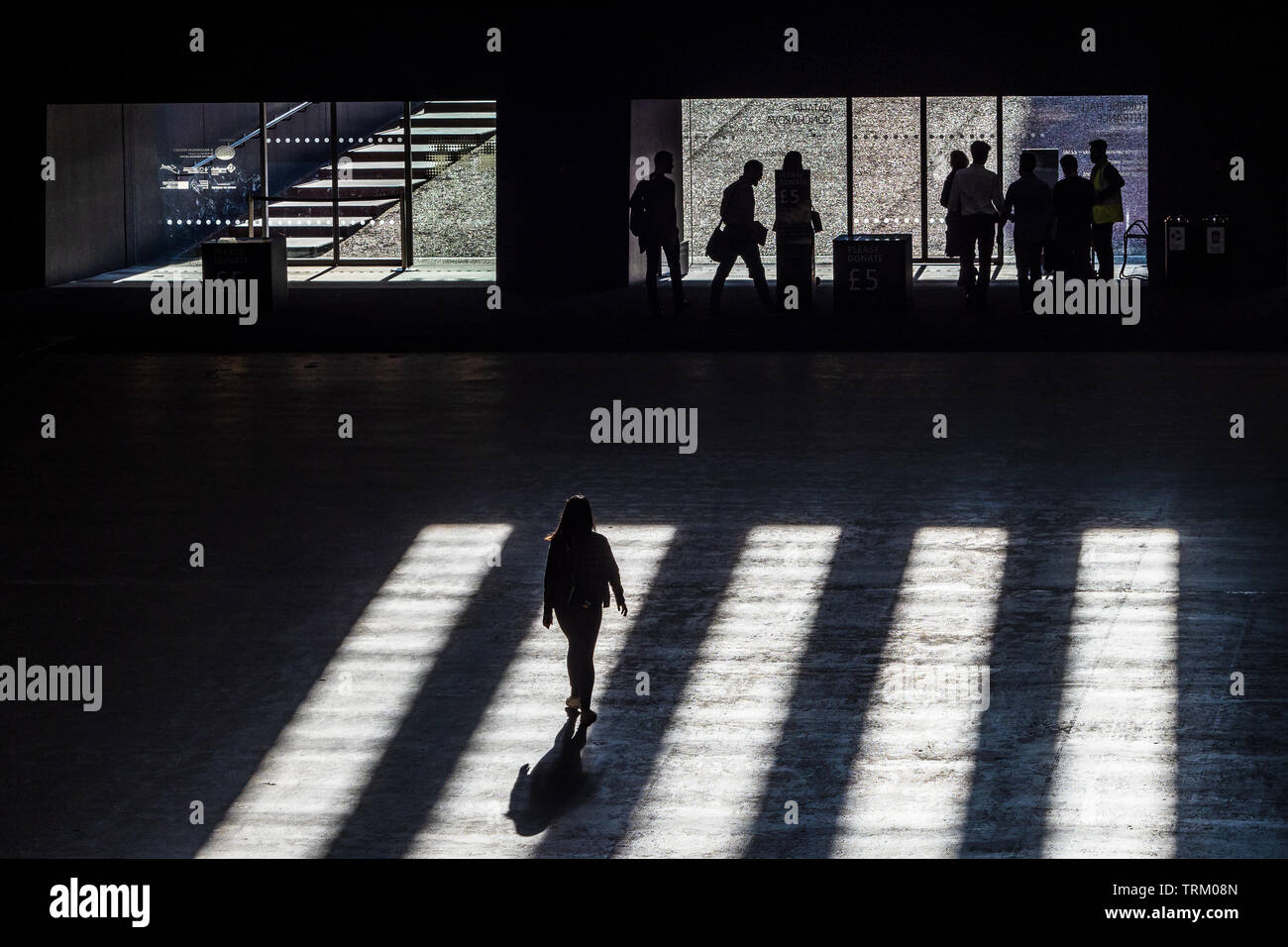Tate Modern Art Gallery - ombre cadono sul popolo in cammino verso la galleria uscire Foto Stock