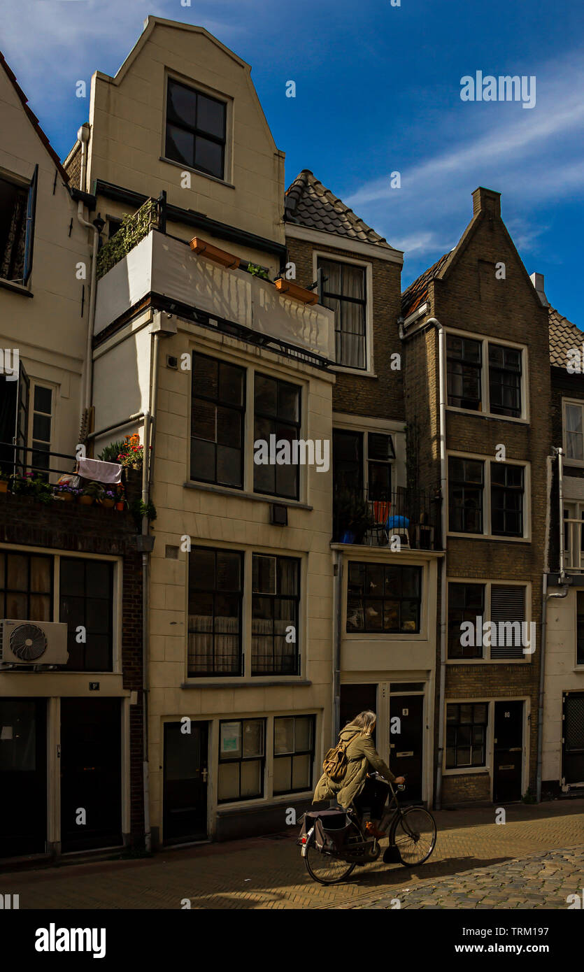 Gouda, Holland, Paesi Bassi, 23 aprile 2019. Il Gouda città vecchia, una tipica strada di stile dautch facciate di case e un ciclista Foto Stock