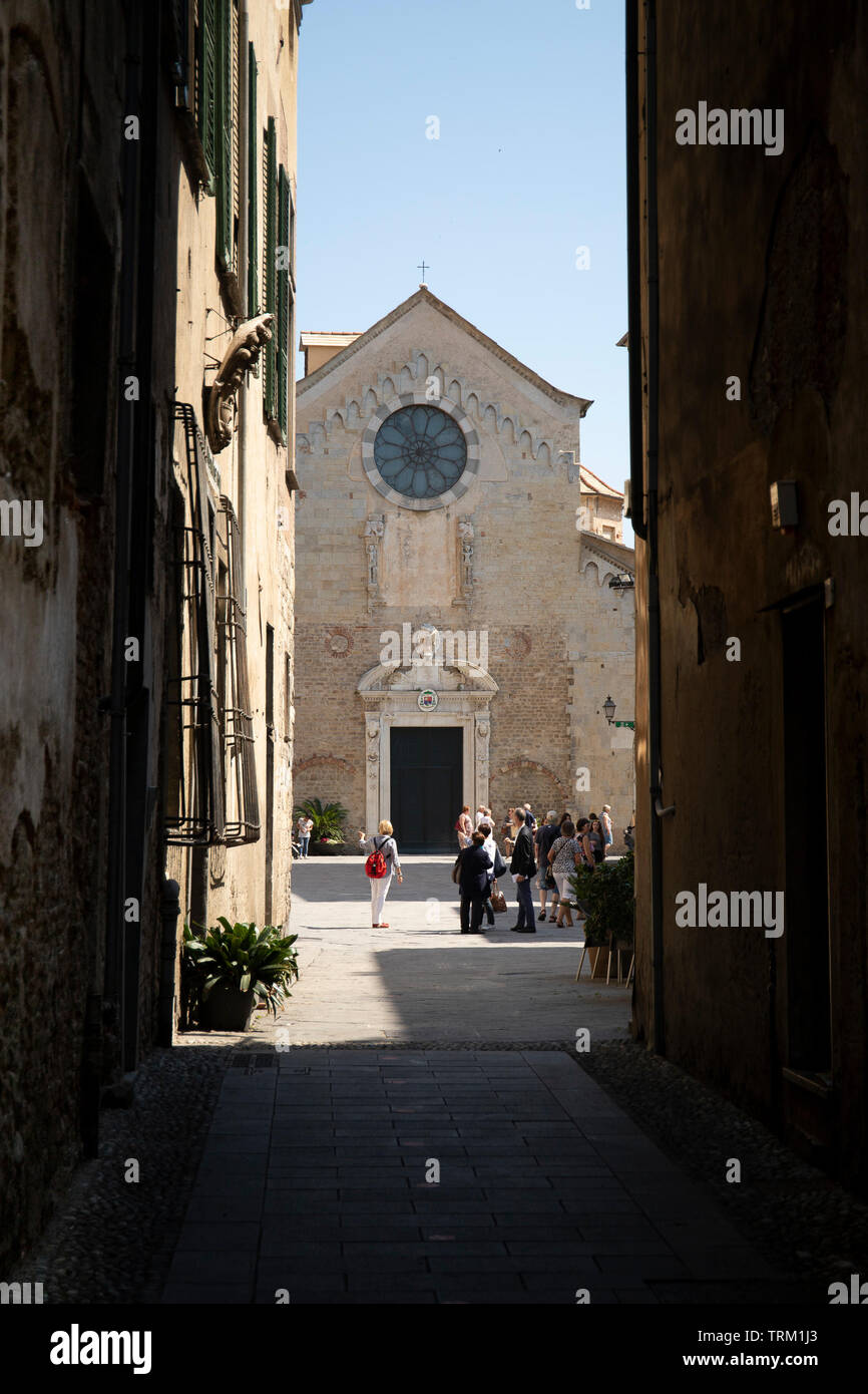 Vicolo stretto con una vista della St Michael cattedrale. Albenga, Liguria. Foto Stock