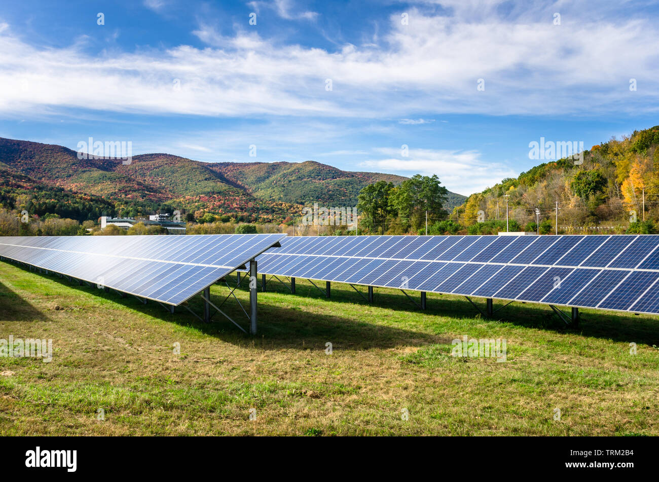 Righe di pannelli solari in un campo in montagna in una soleggiata giornata autunnale Foto Stock
